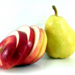 red apple cut in sections and yellow ripe pear isolated on white